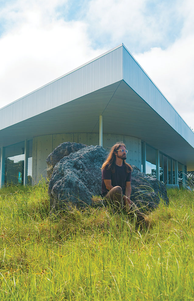 a person sitting on a rock in front of a building