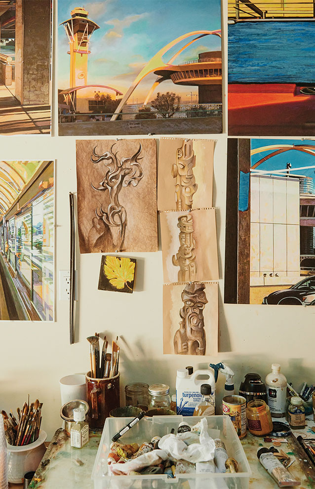 artwork hanging without frames above an artist's station.