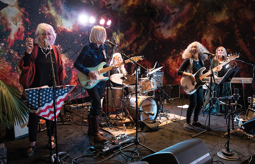 a group of women playing instruments on a stage