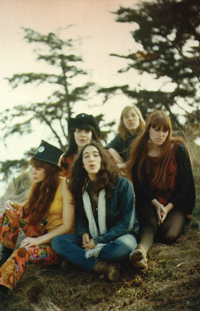 a group of women sitting on grass