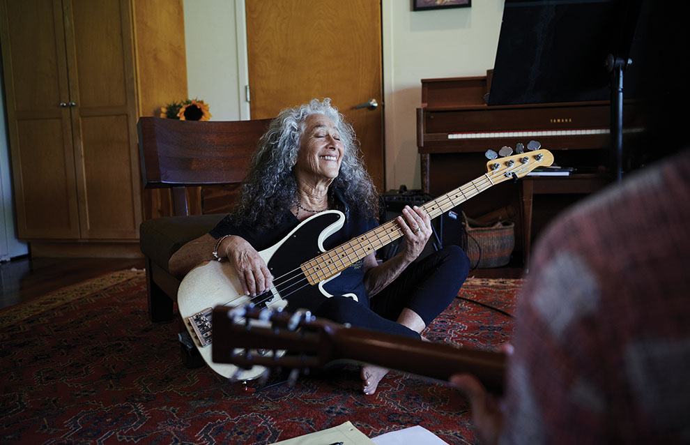 a person sitting on the floor playing a guitar