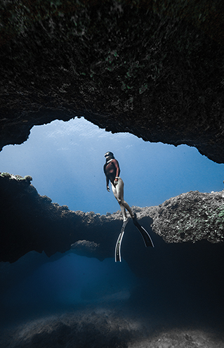 a person in a scuba gear standing on a rock