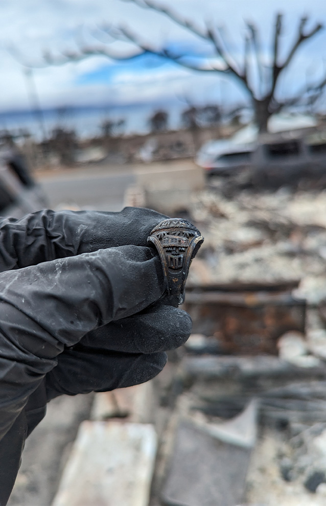 a hand holding a ring that has been buried in ash after a fire
